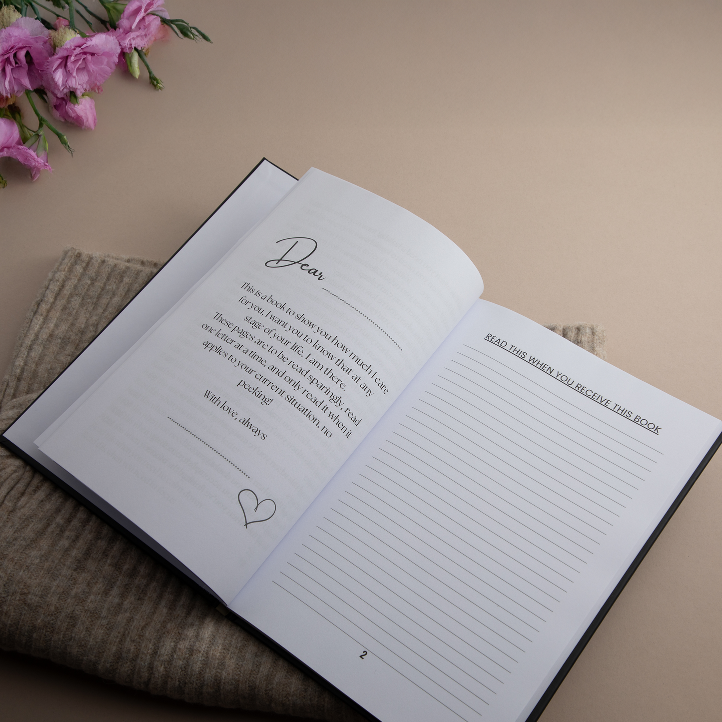 The first page of the book in other words next to some pink flowers and a beige background